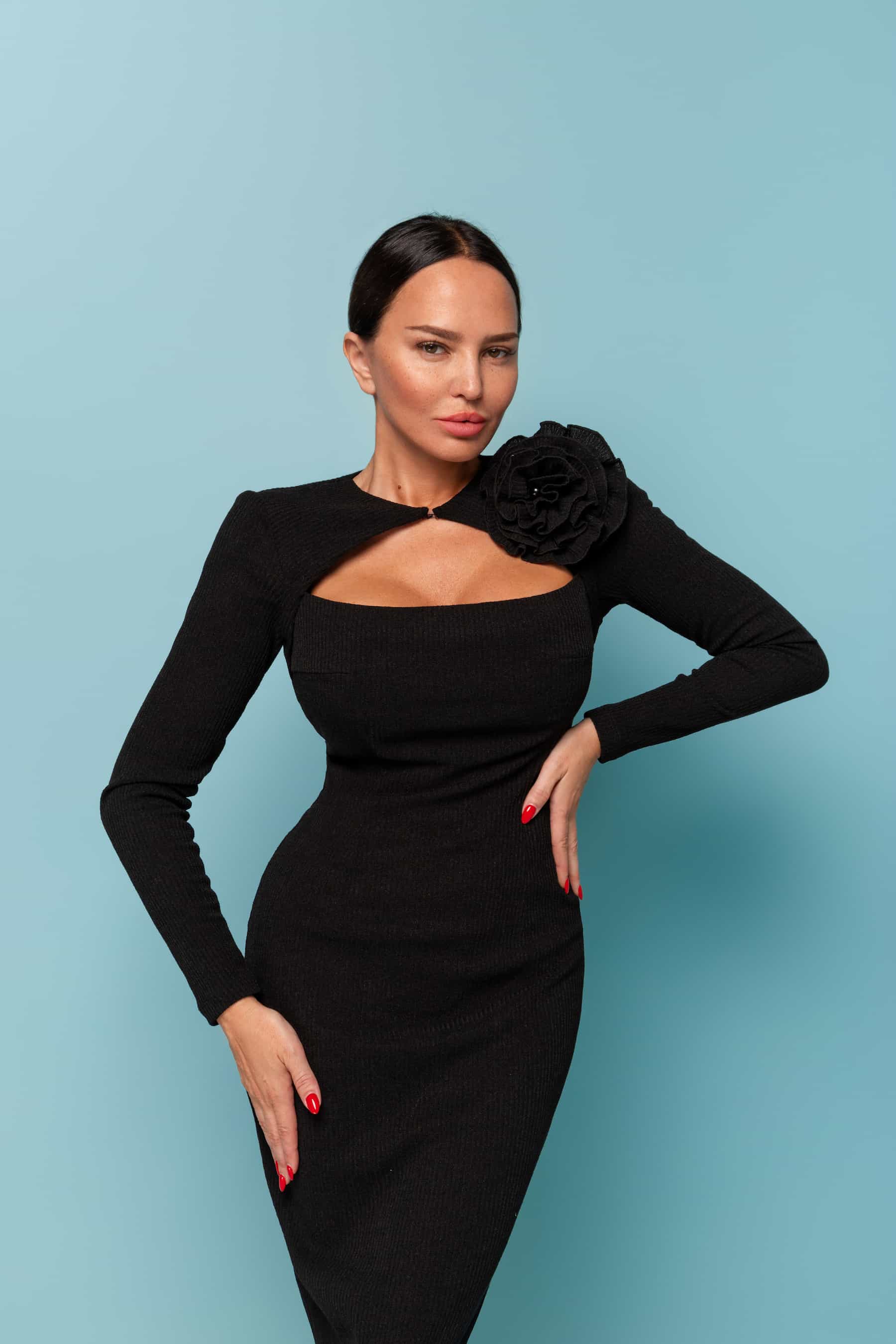 Black dress with a curved neckline and a flower